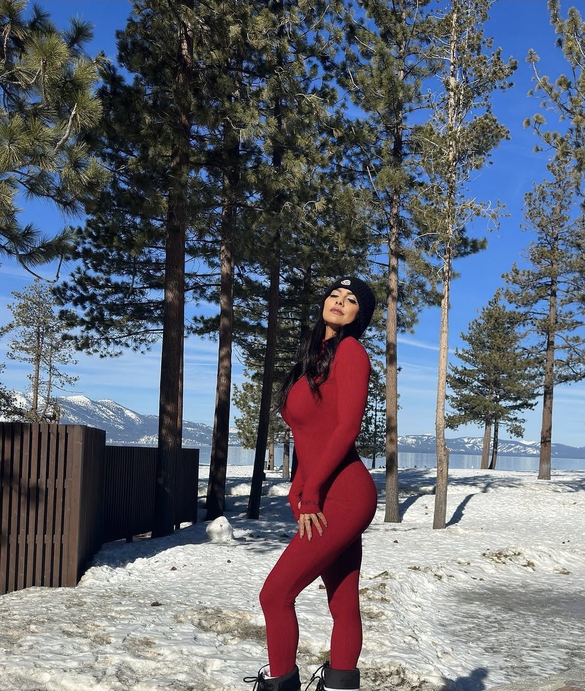 Nakita in a red jumpsuit in the snow among pines at Edgewood Tahoe