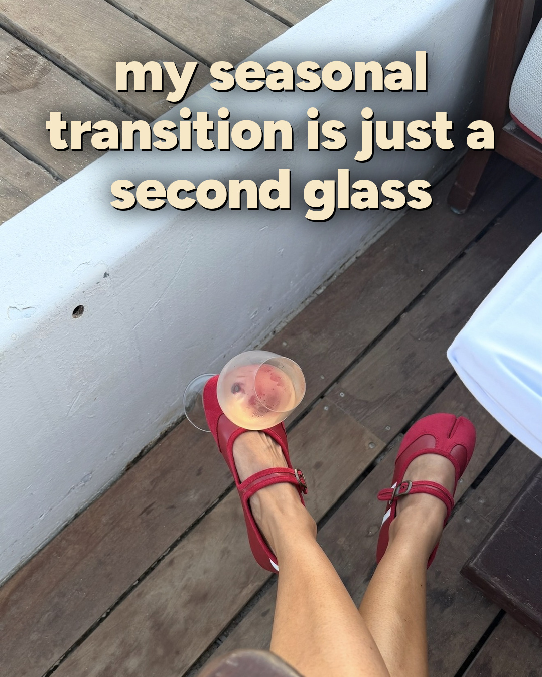 Red flats on a wooden deck with a glass of rosé